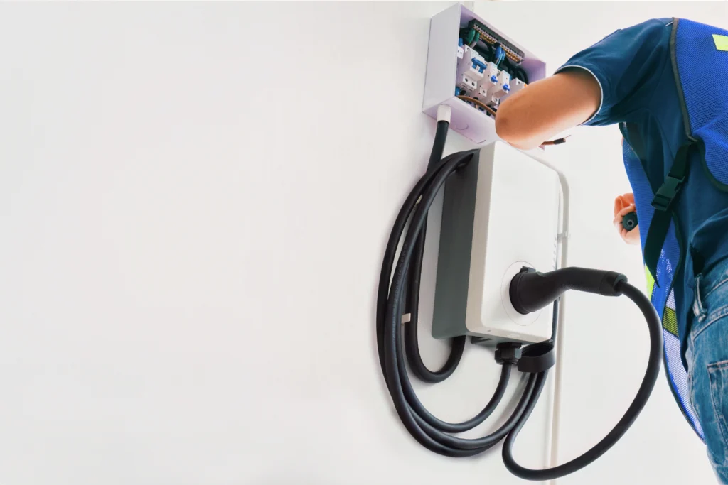 Electrician connecting a home EV wall charger to its circuit protection